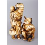 A JAPANESE MEIJI PERIOD STAINED IVORY OKIMONO OF A FAMILY GROUP, the mother standing and bearing a