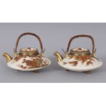 A PAIR OF JAPANESE SATSUMA CIRCULAR TEAPOTS, painted with chrysanthemums with entwined cane handles.