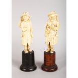 A GOOD EUROPEAN CARVED IVORY OF MEN, in coat and hat. 4.25ins high, on turned wood base.