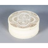 A SMALL CARVED IVORY CIRCULAR BOX AND COVER. 2.75ins.