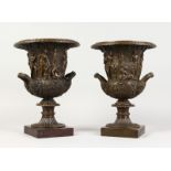 A GOOD PAIR OF BRONZE CLASSICAL TWO-HANDLED URNS on square bases. 12ins high.