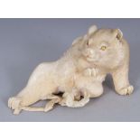 A GOOD QUALITY SIGNED JAPANESE IVORY OKIMONO OF A RECLINING BEAR, its fur naturalistically