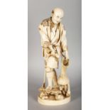 A LARGE JAPANESE CARVED IVORY FIGURE OF A FISHERMAN, carrying a fish and a basket. 11.5ins high.