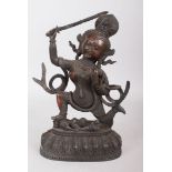 AN EASTERN BRONZE DEITY, holding a sword and snake, standing on a slain figure. 11ins high.