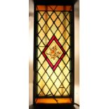 A 20TH CENTURY STAINED GLASS WINDOW, the central lozenge shape panel painted with a bird on a