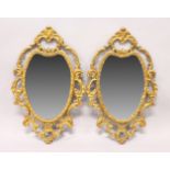 A PAIR OF DECORATED WALL MIRRORS, with gilded gesso frames. 2ft 5ins high x 1ft 6ins wide.