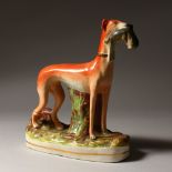 A STFFORDSHIRE MODEL OF A GREYHOUND, standing with a hare in it's mouth. 11ins high.