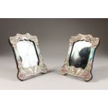 A PAIR OF ART NOUVEAU STYLE SILVER AND ENAMEL PHOTOGRAPH FRAMES. 8ins x 6.25ins.
