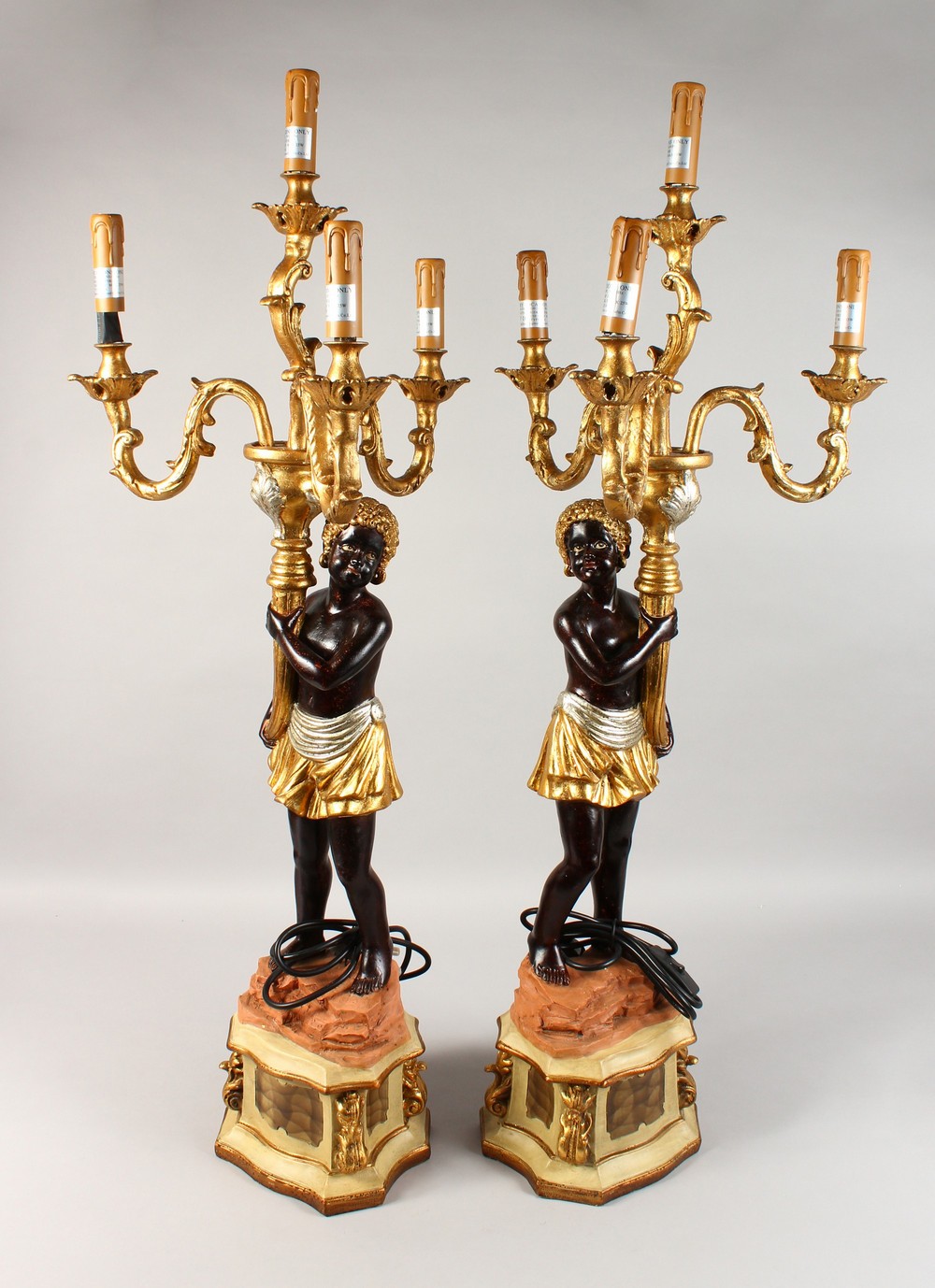 A PAIR OF BLACKAMOOR FOUR-LIGHT CANDELABRA, the stems as Blackamoor figures holding scrolling