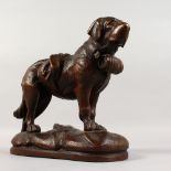 A BLACK FOREST CARVED WOOD SAINT BERNARD DOG. 10ins long.