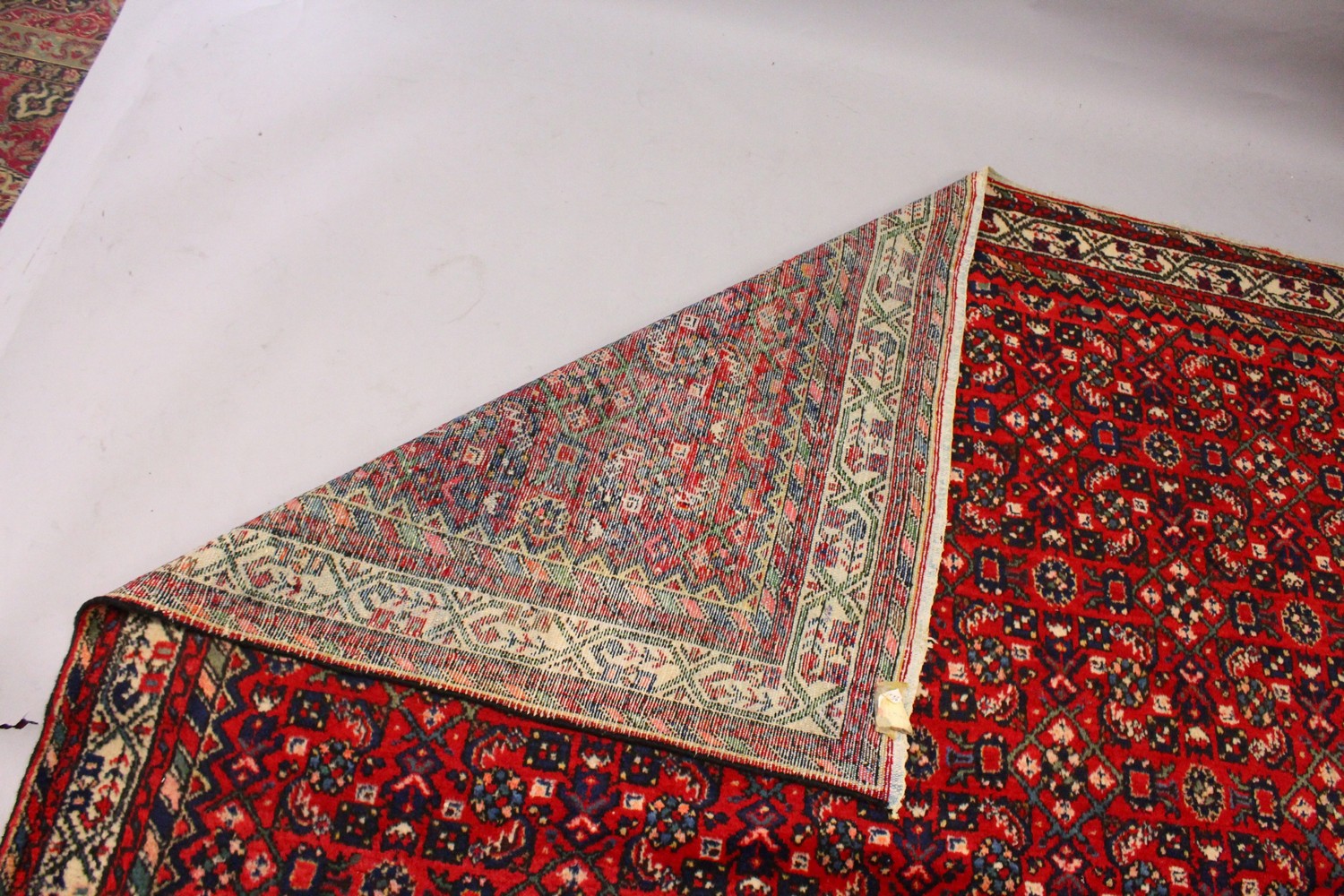 A PERSIAN CARPET, with an all-over design of motifs on a red ground. 9ft 9ins x 7ft. - Image 5 of 6