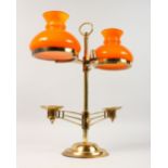A MODERN BRASS TWO-LIGHT CANDLESTICK, with orange glass shades. 15.5ins high.