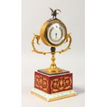 A SMALL VIENNA PORCELAIN AND METAL CLOCK, with circular dial, on a porcelain base. 10ins high.