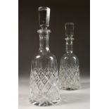 A PAIR OF SLICE CUT MALLET SHAPED SHERRY DECANTERS AND STOPPERS. 12ins high.