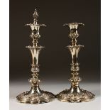 A GOOD PAIR OF WILLIAM IV CANDLESTICK, with repousse decoration. 10.5ins high. Birmingham 1836.
