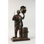 A BRONZE SPILL VASE, modelled as an elderly man with a staff, holding a lantern, with a barrel at