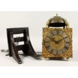 A GOOD BRASS LANTERN CLOCK, with bell, square face and silvered ring, 6.25-inch dial, on a wooden