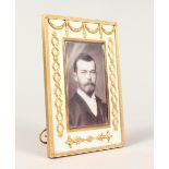 A GOOD RUSSIAN SILVER GILT AND ENAMEL PHOTOGRAPH FRAME, the border applied with swags, laurel