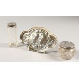 A SMALL OVAL SHAPED PIN TRAY, repousse with angels, London 1904, and two small silver top bowls (