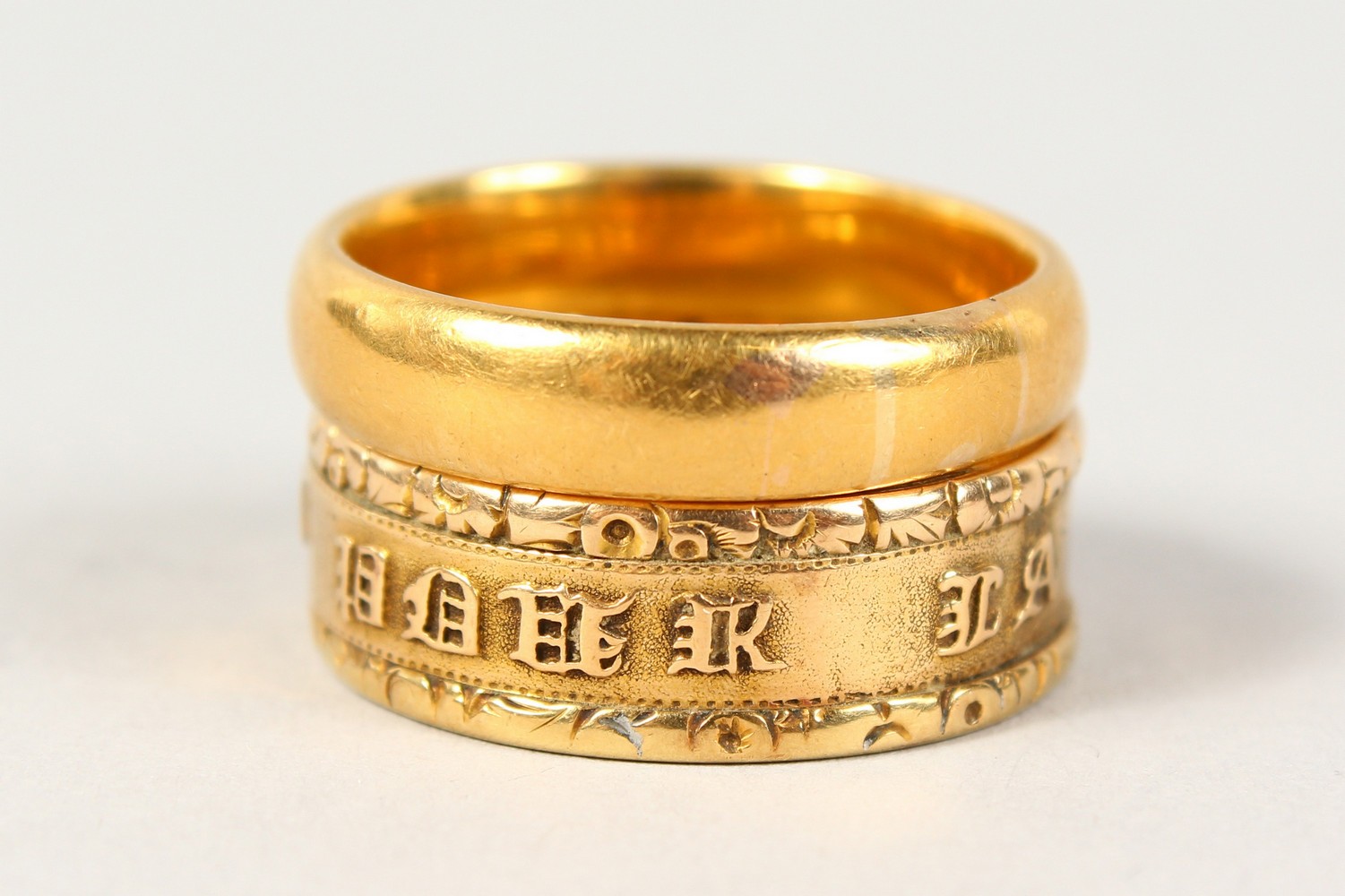 A 22CT GOLD WEDDING BAND, another gold ring with an inscription (2).