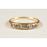 A GOLD NINE STONE DIAMOND RING.