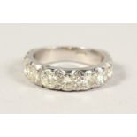 AN 18CT WHITE GOLD NINE STONE HALF HOOP DIAMOND RING.