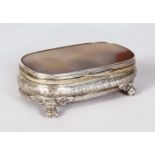 AN AGATE TOP CONTINENTAL SILVER BOX, supported on four claw feet. 5ins wide.