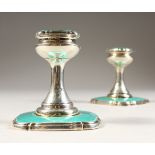 A PAIR OF ART DECO SILVER AND ENAMEL DWARF CANDLESTICKS. London 1910. Makers: Walker & Hall. 3.