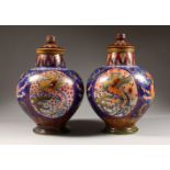 A PAIR OF ITALIAN BULBOUS SHAPED JARS AND COVERS, with lustre decoration. 14.5ins high.