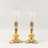 A PAIR OF FRENCH TRUMPET SHAPED VASES, with cut glass holders and gilt metal bases. 14ins high.
