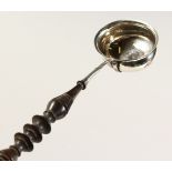 A SILVER TODDY LADLE, inset with a coin. 11ins long.