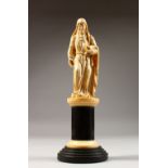 A GOOD 19TH CENTURY CARVED IVORY FIGURE, of a lady carrying a book, on a turned pedestal base.