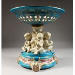 A GOOD LARGE SEVRES DESIGN PORCELAIN COMPORT, with pierced bowl, the stand as three cupids. 12ins