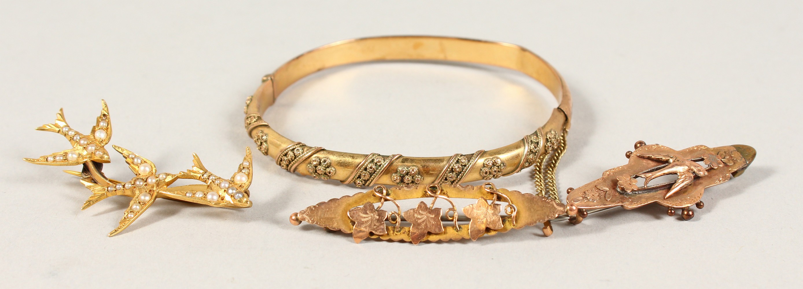 A 9CT GOLD BRACELET and THREE BROOCHES.