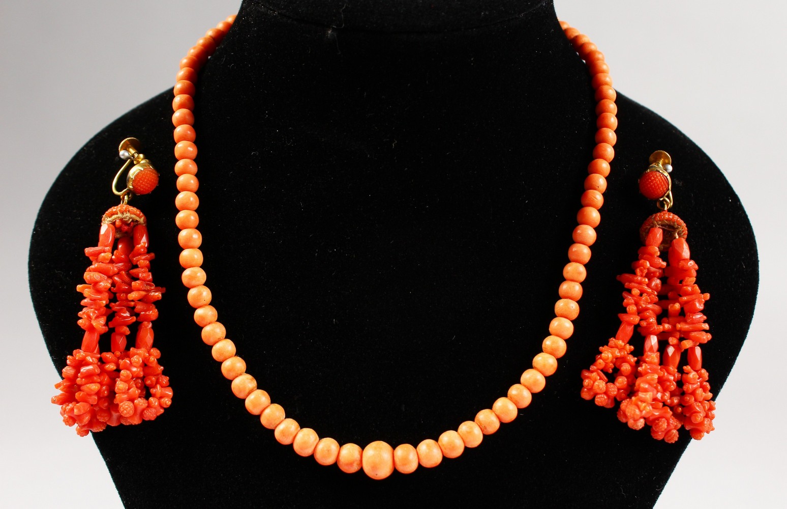 A PAIR OF CORAL DROP EARRINGS and A SINGLE ROW NECKLACE.