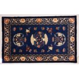 A SMALL CHINESE CARPET, with blue ground, with design of storks. 6ft 9ins x 4ft 4ins.