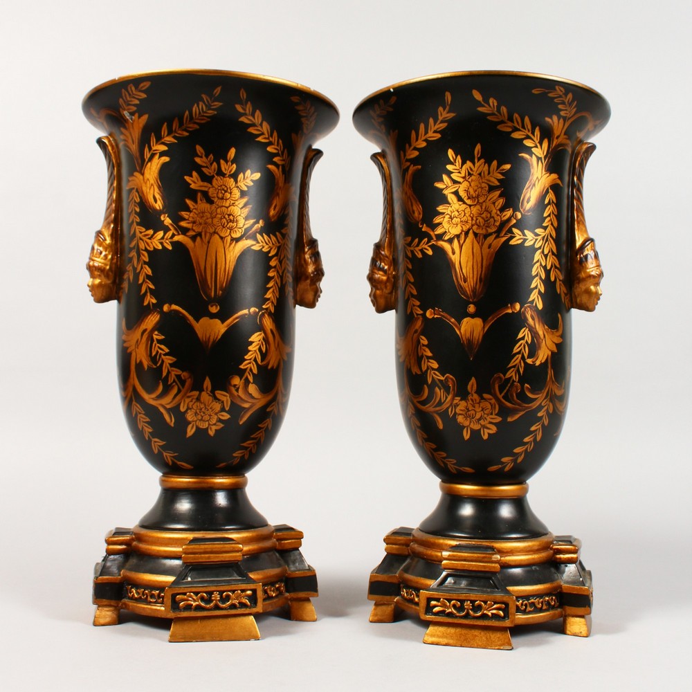 A PAIR OF BLACK PORCELAIN TOLEWARE TYPE URNS ON STANDS. 13ins high.