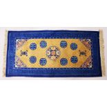 A CHINESE RUG, with beige ground, central motif and eight blue motifs. 5ft x 2ft 3ins.