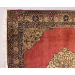 A PERSIAN CARPET, with rose ground, central motif, motifs to the border. 7ft 2ins x 7ft 4ins.