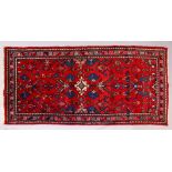 A PERSIAN RUG, with red and blue design. 6ft 8ins x 3ft 4ins.