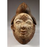 A CARVED AND PAINTED TRIBAL MASK. 13ins high.