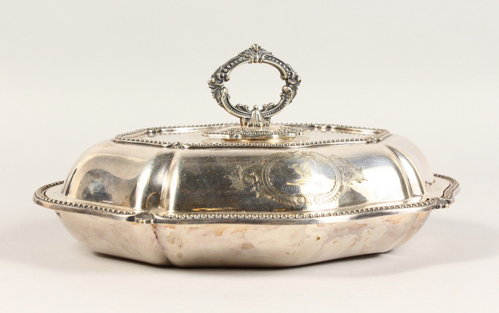 AN ENTREE DISH AND COVER, with engraved crest. 12.5ins wide.