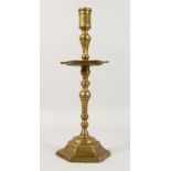 AN EARLY HEXAGONAL BRONZE CANDLESTICK, with integral drip pan. 15.5ins high.