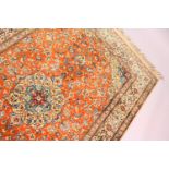 A PERSIAN PART SILK RUG, rust ground with stylised floral design. 6ft 6ins x 3ft 10ins.