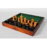 A TWO-COLOURED BOXWOOD CHESS SET in a box. One black pawn missing.