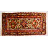 A PERSIAN RUG, with three central motifs. 5ft x 2ft 4ins.