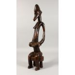 A SENUFO TRIBE SEATED FIGURE, Mother and Child. 19ins high.