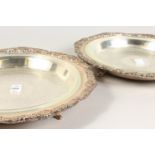 A PAIR OF CIRCULAR DISHES, shell cast borders and glass liners. 14ins diameter.