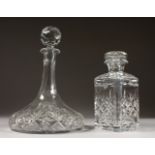 A CUT GLASS SQUARE WHISKY DECANTER AND STOPPER and A SHIPS DECANTER AND STOPPER (2).