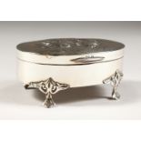 AN EDWARD VII OVAL JEWELLERY BOX, the lid repousse with angels, on four claw feet. 3.5ins.